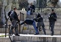 Израильская полиция проводит досмотр личных вещей палестинца, задержанного в Старом городе Иерусалима.