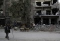 Сирийский мужчина пасет овец у своего разрушенного дома в Дамаске