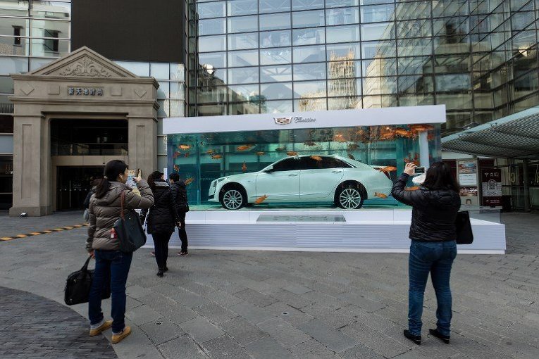 Пешеходы делать снимки нового Cadillac CT6, погруженного в гигантский аквариум в Шанхае