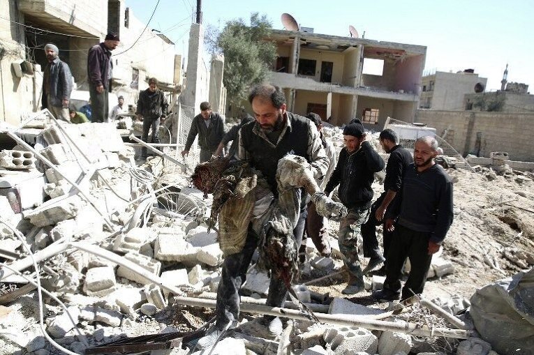 Представители Сирийского Арабского Красного Полумесяца и местные жители ищут выживших после авиаудара в сирийском городе Дума