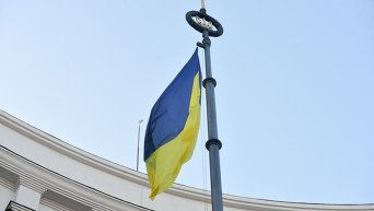 Герб и флаг Украины над зданием Кабмина Украины.