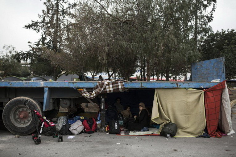 Семья беженцев в порту Пирей близ Афин