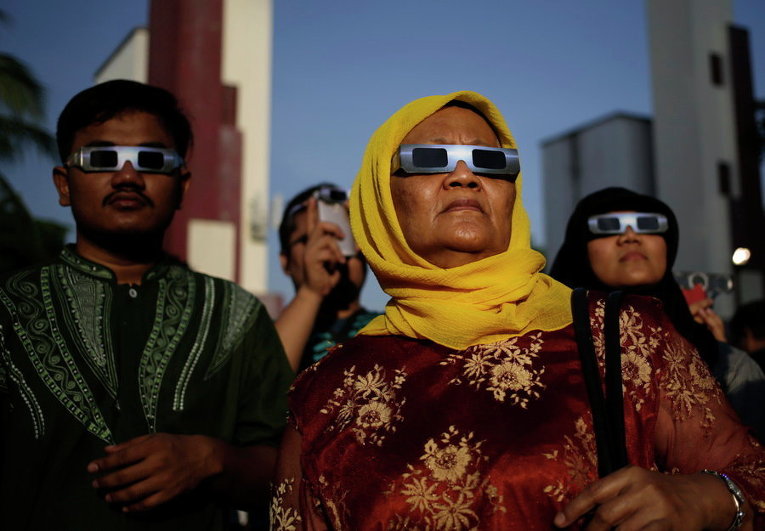 Люди наблюдают солнечное затмение в Джакарте, Индонезия