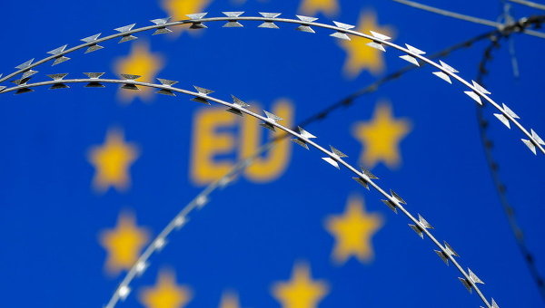 Колючая проволока на фоне символа Евросоюза