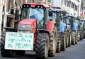 Европейские фермеры принимают участие в демонстрации в Брюсселе, Бельгия. Плакат на тракторе гласит: SOS, я фермер. Я умираю
