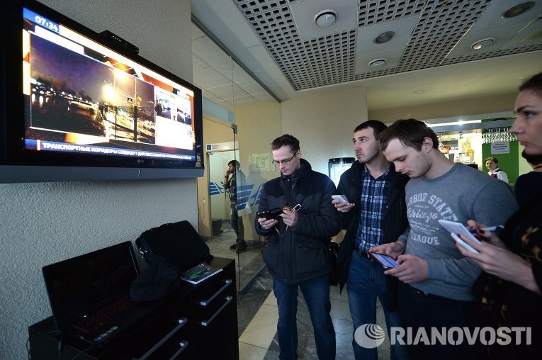 Люди стоят у телевизора в аэропорту Ростова-на-Дону, где разбился Boeing-737-800