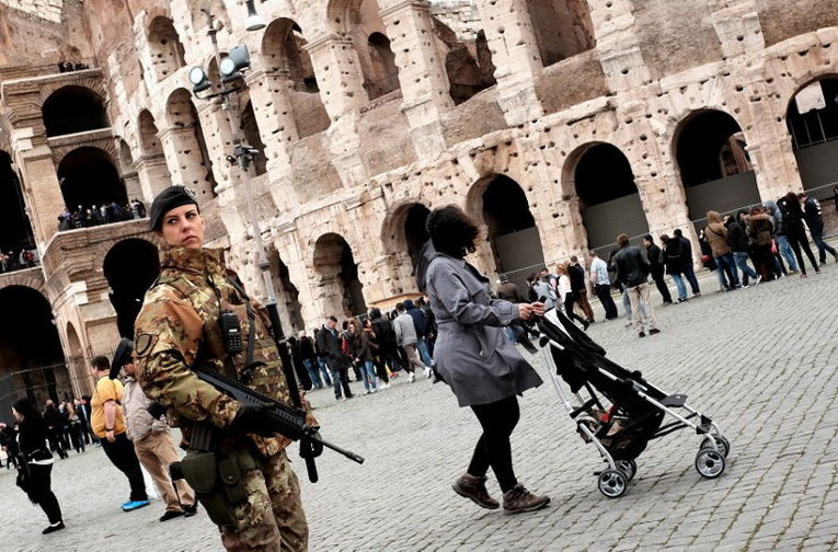 Итальянский солдат стоит у Колизея во время патрулирования в Риме после повышенных мер безопасности из-за нападений в Брюсселе