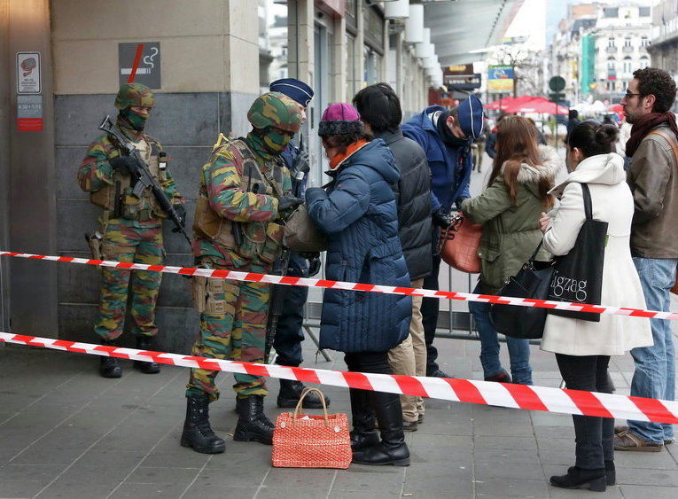 Бельгийские военные обыскивают людей, входящих на станцию метро, после нападений в Брюсселе, Бельгия