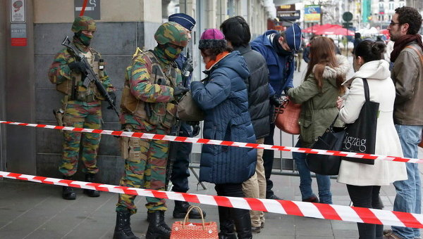 Бельгийские военные обыскивают людей, входящих на станцию метро, после нападений в Брюсселе, Бельгия