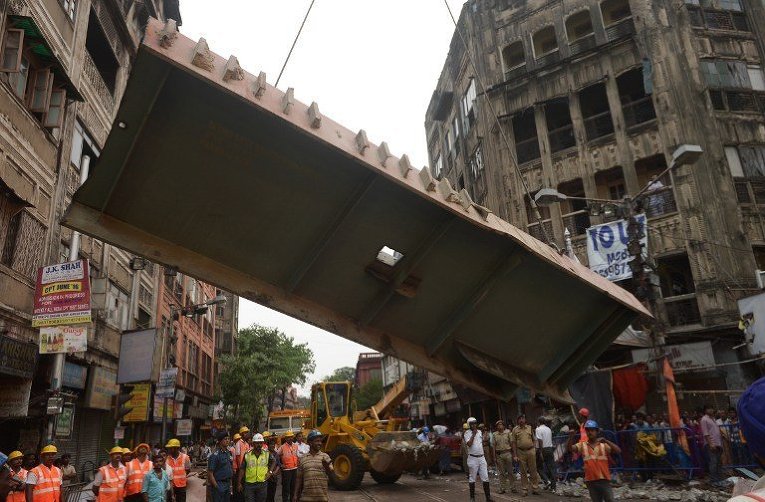 Индийские спасатели пытаются освободить людей, оказавшихся под обломками рухнувшего эстакады в Калькутте, погибли по меньшей мере 22 человек и получили ранения более 100 человек.