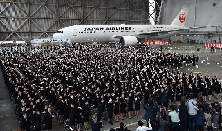 Новые сотрудники Japan Airlines во время церемонии выхода из ангара нового Boeing 777 в аэропорту Ханеда, Токио