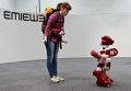 Робот EMIEW3 и представитель СМИ на выставке в Токио
