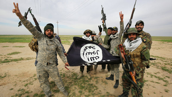Иракские шиитские бойцы с захваченным флагом ИГ. Архивное фото