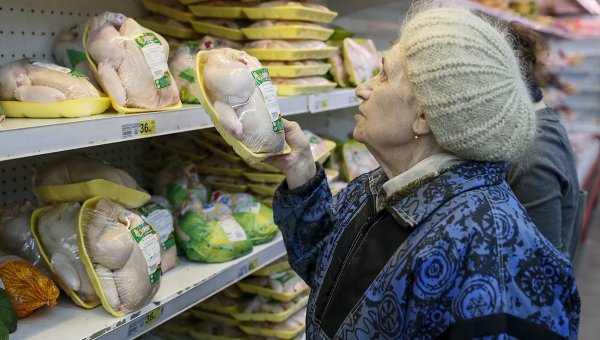 Пенсионерка в магазине выбирает курятину