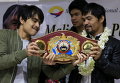 Филиппинский чемпион по боксу Пакьяо и его старший сын Джимвел показывают чемпионский пояс по прибытии в международный аэропорт имени Бениньо Акино в Маниле