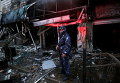 Палестинский полицейский у сгоревшего здания в городе на Западном берегу Эль-Бире