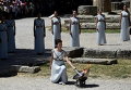 Греческая актриса, выступая в качестве верховной жрицы, зажигает олимпийский огонь в храме Геры в Олимпии