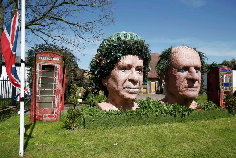 Два гигантских бюста британской королевы Елизаветы и принца Филиппа на выставке в саду близ Виндзор, Великобритания