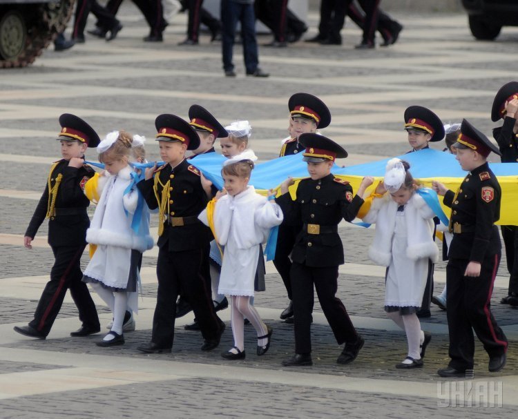 Кадеты и школьницы держат флаг Украины во время создания живого тризуба в Киеве