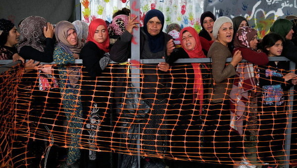 Женщины в очереди за бесплатной одеждой в импровизированном лагере для беженцев на греко-македонской границе близ села Идомени