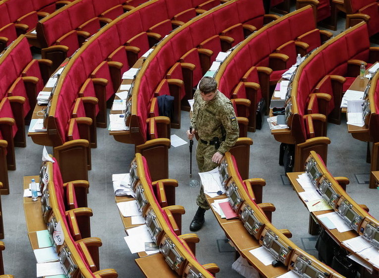 Военнослужащий СБУ проверяет зал Парламента перед началом заседания в Киеве