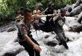 Индонезийские полицейские и местные жители несут тело жертвы наводнения на Северной Суматре