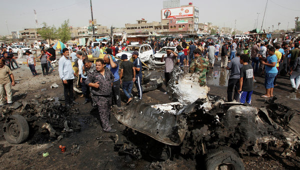 Иракские силы безопасности и жители на месте взрыва заминированного автомобиля в шиитском районе Багдада Садр-Сити. Архивное фото