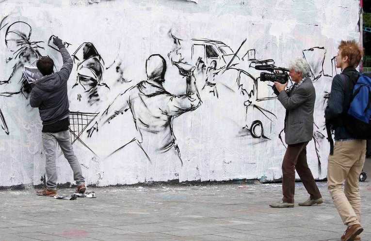 Уличный художник выражает протест против нового трудового законодательства во Франции