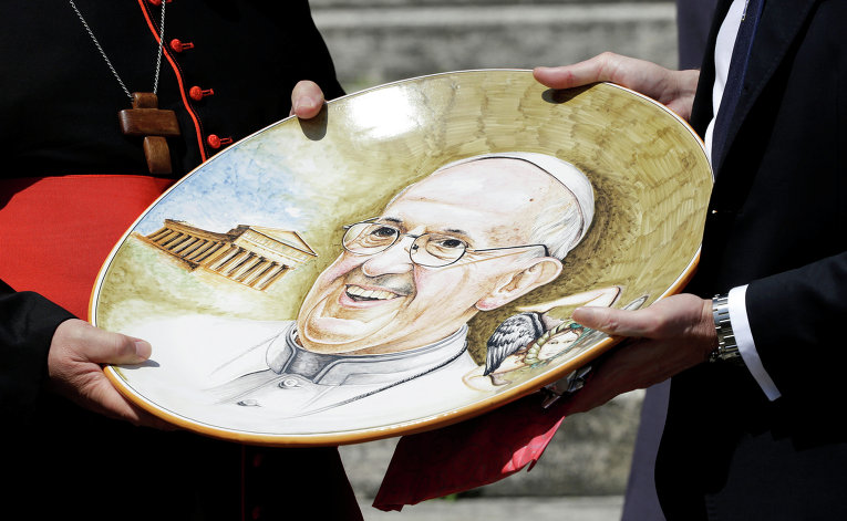 Кардиналы держат тарелку с изображением Папы Римского Франциска