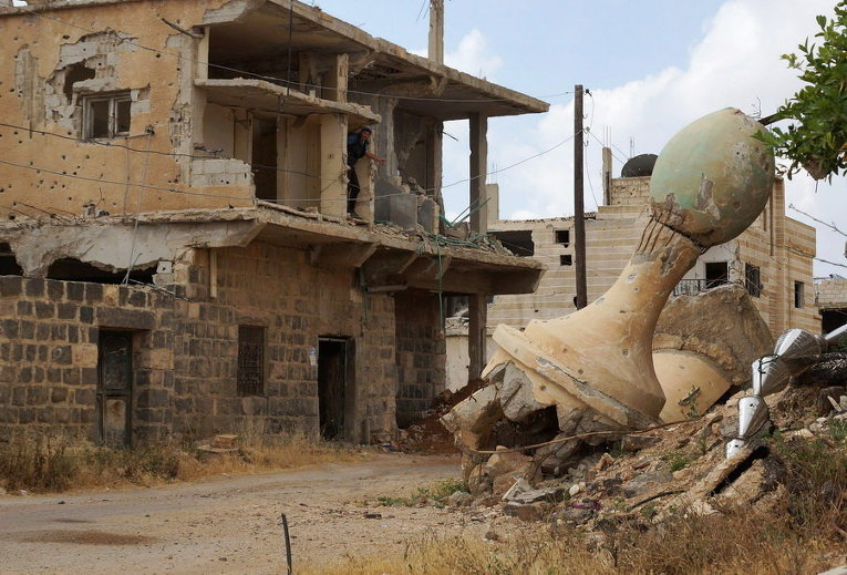Поврежденный минарет мечети в удерживаемом повстанцами районе Дараа, Сирия