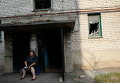 Жительница города Ясиноватая у поврежденного в результате артобстрела дома. Архивное фото
