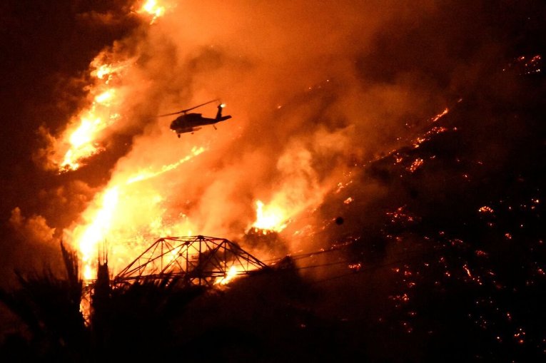 Пожарный вертолет борется с крупным пожаром, охватившим часть штата Калифорния.