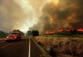 Пожарный вертолет борется с крупным пожаром, охватившим часть штата Калифорния
