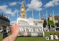 Мужчина держит в руке газету у здания парламента в Лондоне после референдума