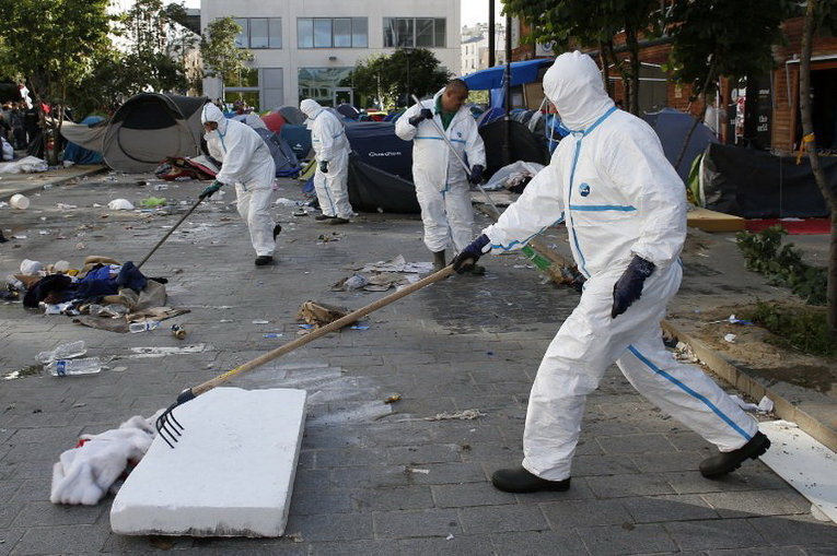 Работники очищают место, где был лагерь мигрантов в Париже