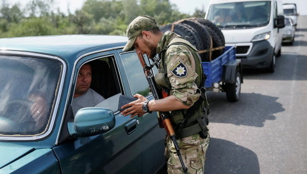Военнослужащий проверяет документы на КПП в Донецкой области