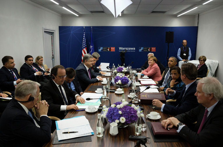 Президент Франции Франсуа Олланд (за столом второй слева), президент Украины Петр Порошенко (за столом четвертый слева), премьер-министр Италии Маттео Ренци (за столом пятый слева) премьер-министр Великобритании Дэвид Кэмерон (второй справа), президент США Барак Обама (за столом четвертый справа) и федеральный канцлер ФРГ Ангела Меркель (за столом пятая справа) во время встречи в рамках саммита НАТО в Варшаве