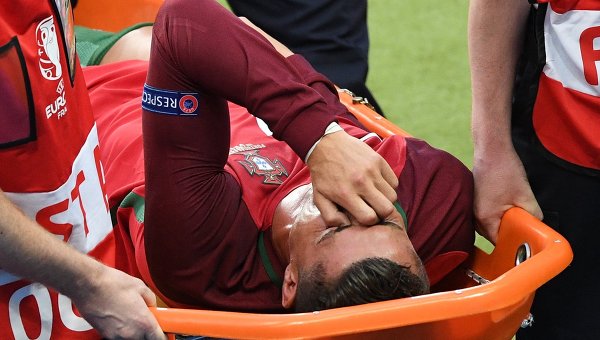 Медики выносят на носилках с поля игрока сборной Португалии Криштиану Роналду
