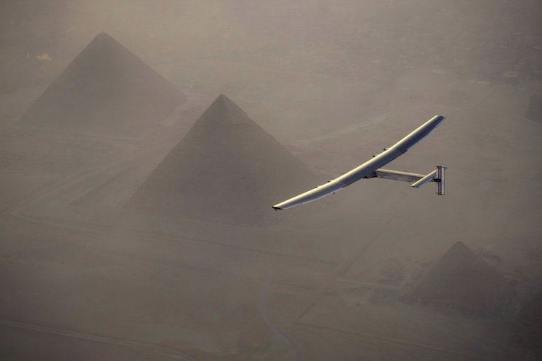 Самолет Solar Impulse 2, работающий от солнечной энергии, на фоне пирамид перед посадкой в Каире, Египет