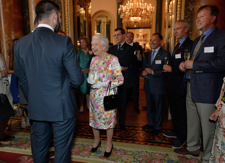 Королева Великобритании Елизавета II  говорит с гостями во время приема в Букингемском дворце