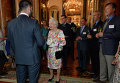 Королева Великобритании Елизавета II  говорит с гостями во время приема в Букингемском дворце