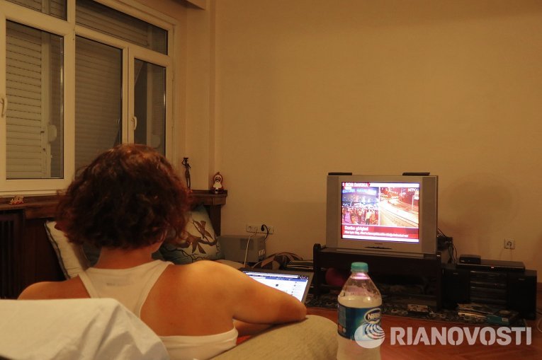 Девушка смотрит новости по телевизору в турецком городе Стамбуле