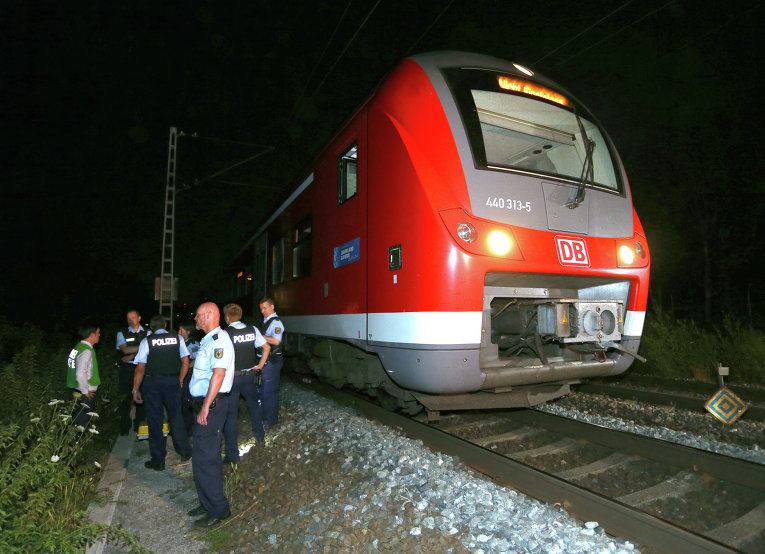Несовершеннолетний мигрант из Афганистана совершил нападение с топором на пассажиров поезда в Германии, тяжело ранив четырех человек. Полицейские на месте преступления.