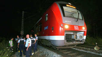 Несовершеннолетний мигрант из Афганистана совершил нападение с топором на пассажиров поезда в Германии, тяжело ранив четырех человек. Полицейские на месте преступления.