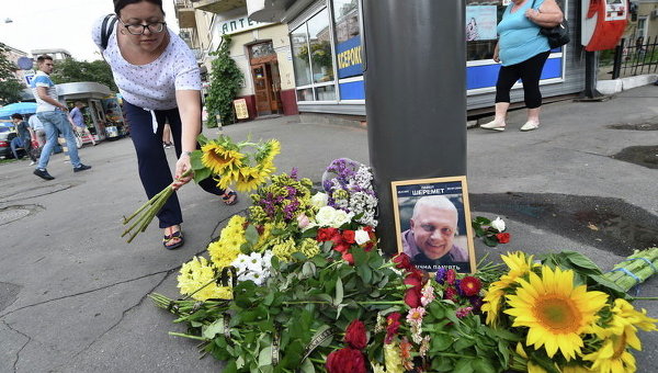 Женщина возлагает цветы на месте, где погиб журналист Павел Шеремет в центре Киева 20 июля 2016 года