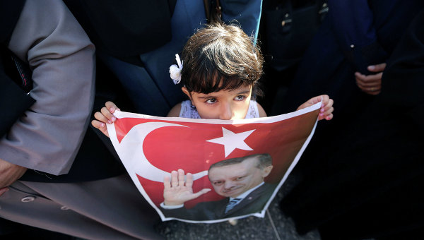 Девочка держит плакат с изображением президента Турции Тайипа Эрдогана