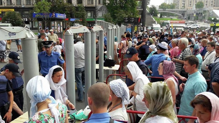 Паломники Крестного хода проходят через рамки металлоискателя в Киеве