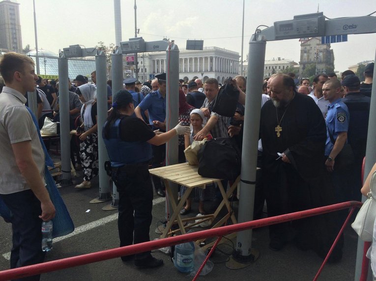 Паломники Крестного хода проходят через рамки металлоискателя в Киеве