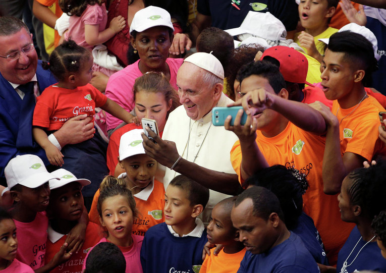 Папа Римский Франциск фотографируется с беженцами в Ватикане