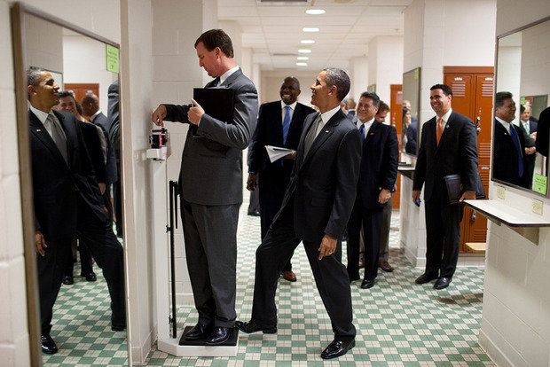 Барак Обама в шутку нажимает на весы. Президент должен иметь чувство юмора и именно это должен передать фотограф.